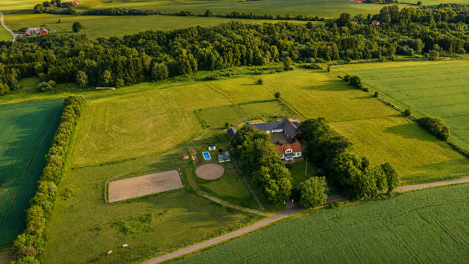 Aerial view of Åkeslund surrounded by paddocks, fields and woodland